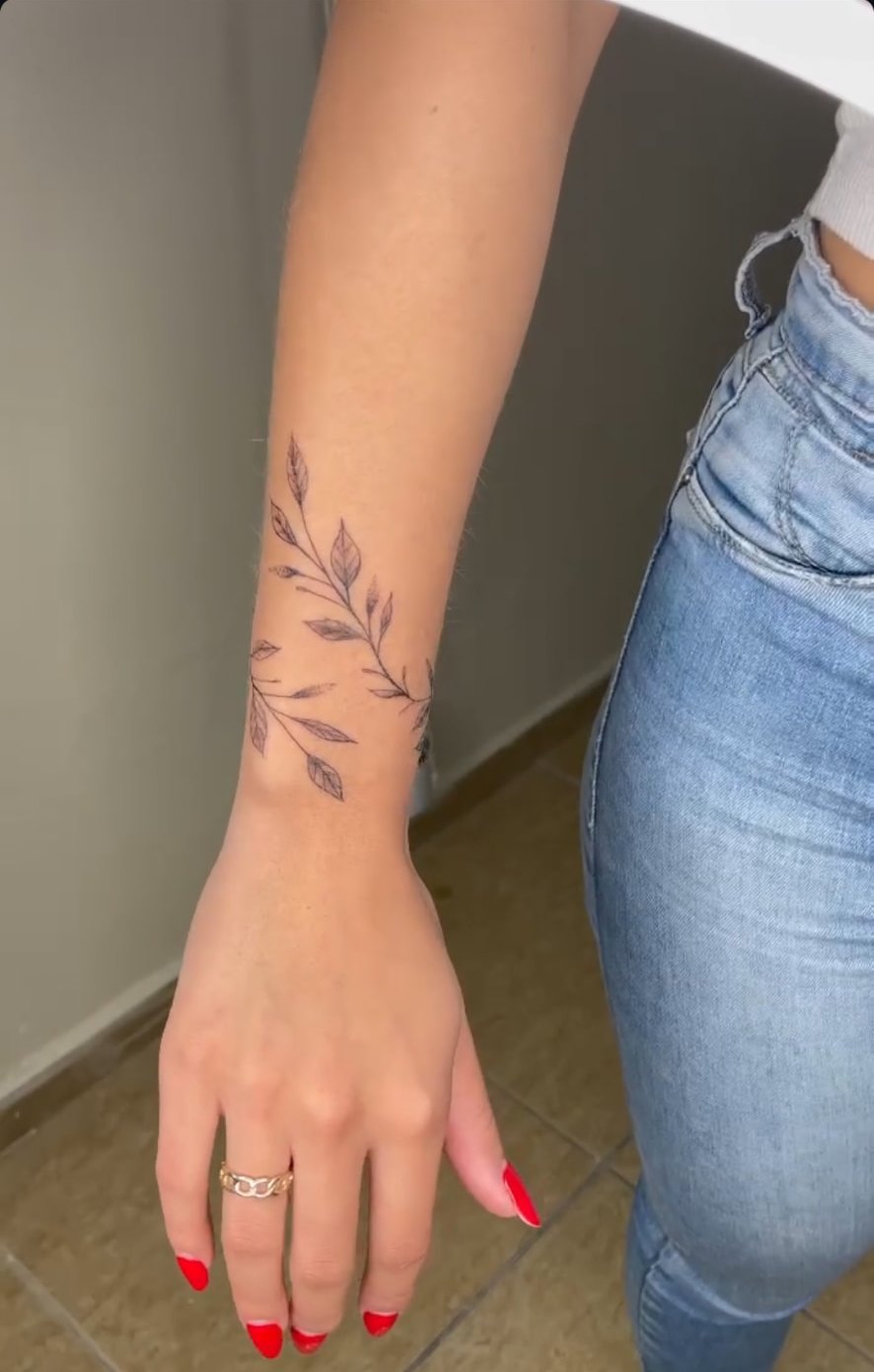Tattoo fineline de ramo com folhas no antebraço