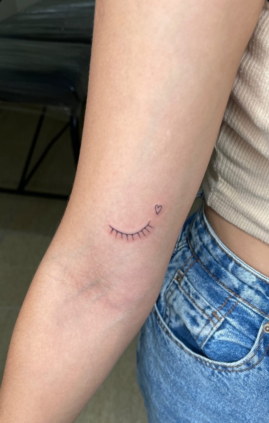 Tattoo fineline minimalista de olho fechado com coração